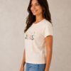 Baby Look Cristã Jesus Off White | KeA Shop Vista lateral da Baby Look Cristã Jesus off white da KeA Shop em modelo.